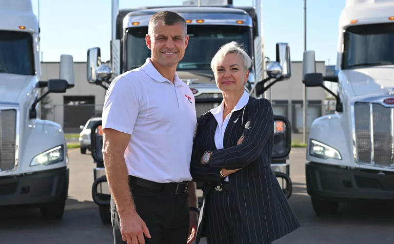 HMD Trucking team members standing in front of trucks
